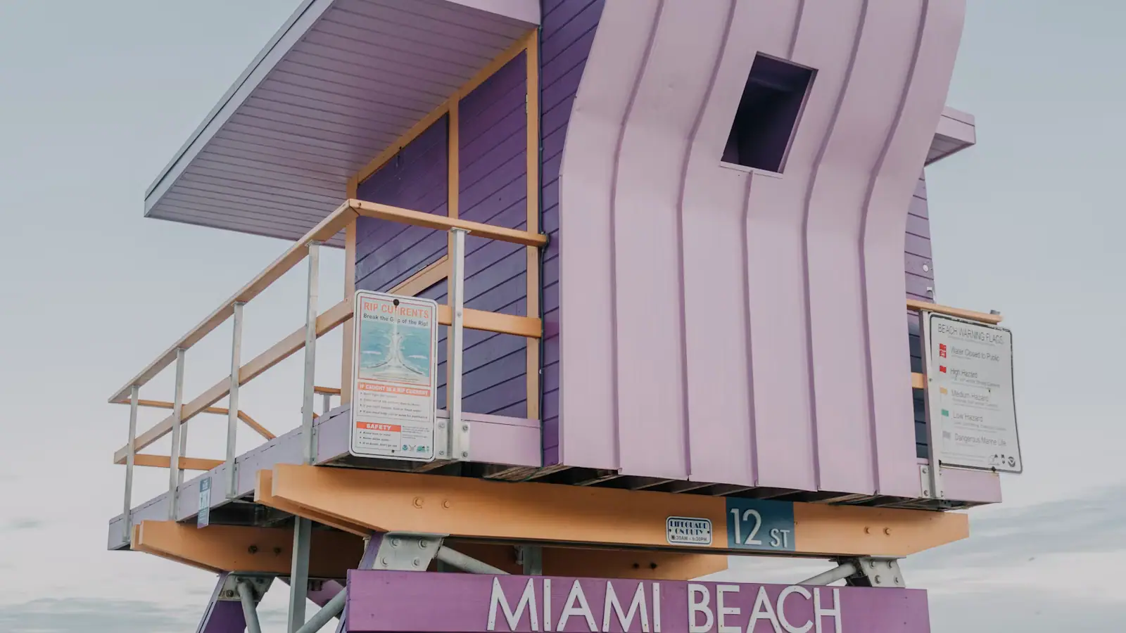A lilac wooden lifeguard stand on Miami Beach marked with the street number 12